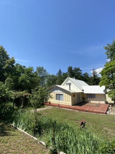 a large yellow house with a large yard at Columbia Point Resort in Kettle Falls