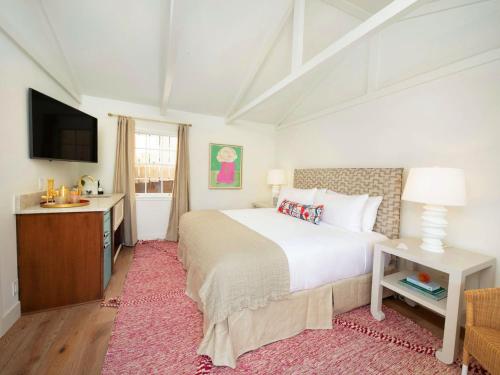 a bedroom with a large bed and a television at Farmhouse Paso in Paso Robles