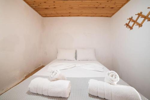 Un dormitorio con una cama blanca con toallas. en MinoaHouse 1 bedroom,3 guests,bath tub & patio, en Ierápetra