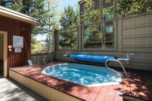 a hot tub on a deck next to a building at A Perfect Location Walk to EVERYTHING Onsite Hot Tubs Grill And Pool SH52 in Breckenridge