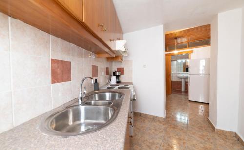 a kitchen with a stainless steel sink and a stove at MinoaHouse 1 bedroom,3 guests,bath tub & patio in Ierápetra