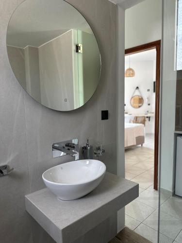a bathroom with a white sink and a mirror at Electra Studios in Palaiochóra