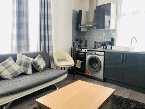 a living room with a couch and a washing machine at The Whitehouse in Blackpool