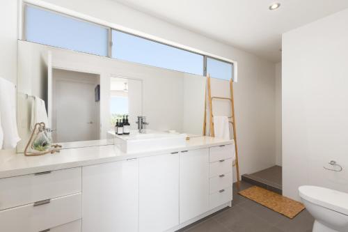 a white bathroom with a sink and a mirror at Jetty Beach Retreat - Blairgowrie Luxury Family Retreat 5 Bed Heated Pool in Blairgowrie