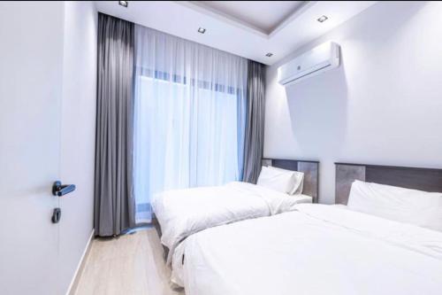 two beds in a room with a window at Luxury Almalqa شقة فاخرة الملقا in Riyadh