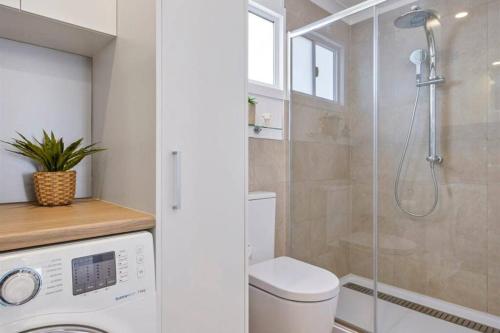 a bathroom with a toilet and a glass shower at Cosy Cabin, Big View ! in Primrose Sands