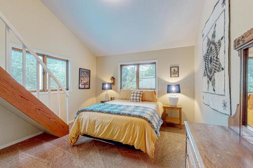 a bedroom with a bed and a staircase with windows at Juniper Haven Retreat in Sun Valley