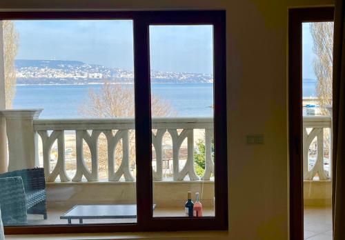 ein Fenster mit Meerblick vom Balkon in der Unterkunft Seaside Serenity - luxurious beach-front apartment with a refreshing pool in Warna