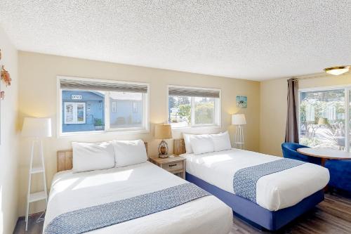 2 camas en una habitación con 2 ventanas en The Lamplighter Inn - Crab Shack and Whale Watching en Bandon