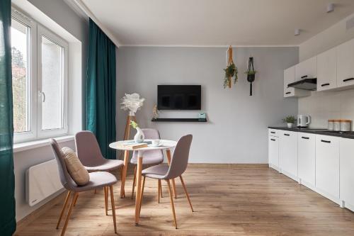 uma cozinha e sala de jantar com mesa e cadeiras em LAS I GÓRY Jedlina-Zdrój. Apartament na 5 em Jedlina-Zdrój