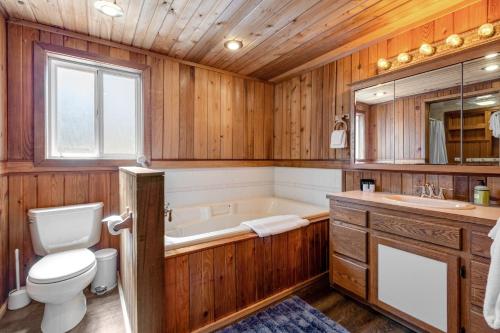 a bathroom with a tub and a toilet and a sink at Skiou Point Beach House in Tulalip