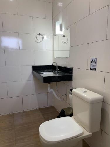 ein weißes Bad mit einem WC und einem Waschbecken in der Unterkunft Rancho do Tomate in São Roque de Minas