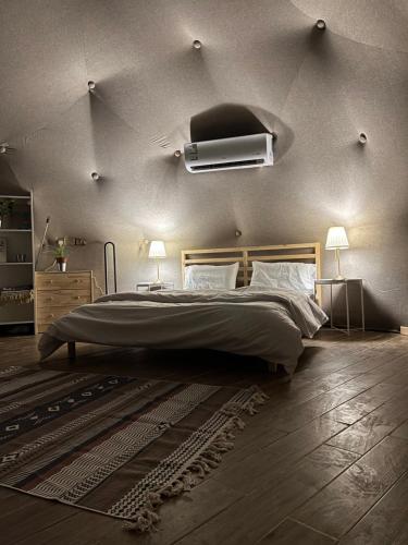 a bedroom with a large bed and two lamps at Albaha domes in Rahwat al Barr