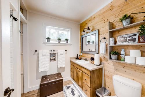 baño con paredes de madera, lavabo y espejo en Moose Haven, en Garden City