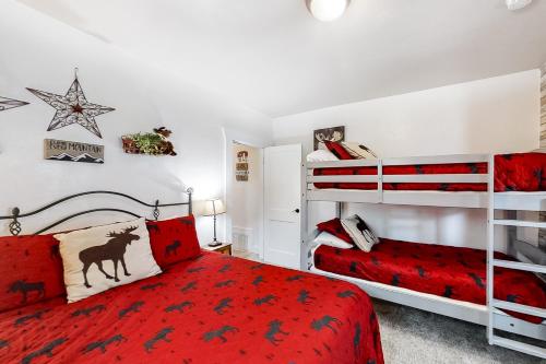 een slaapkamer met 2 stapelbedden en een rode sprei bij Moose Haven in Garden City