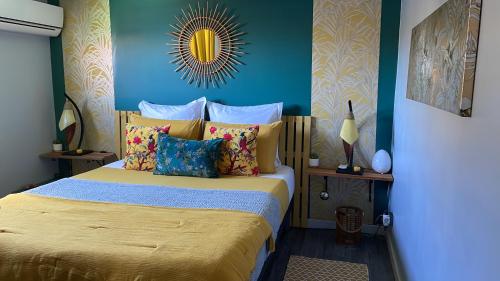 a bedroom with a bed with yellow sheets and blue walls at Appartement vue mer, Case Pilote in Case-Pilote