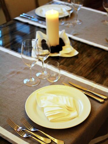 a table with a white plate and glasses and a candle at Hotel La Pigna in Marina di Pietrasanta
