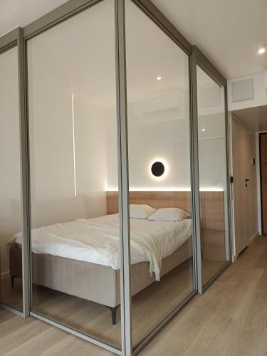 1 dormitorio con puertas correderas de cristal alrededor de una cama en Apartament Wydma Darłowo Solaris, en Darłowo
