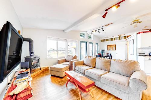 a living room with a couch and a tv at Evinrude Escape in Coupeville