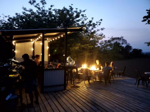 een groep mensen die 's nachts op een terras zitten bij Yumas Riverfront Lodge in San Ignacio