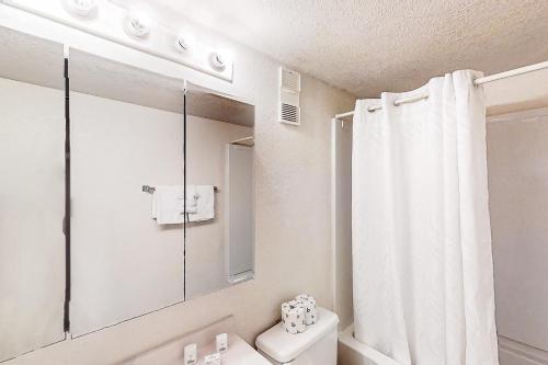 a white bathroom with a shower curtain and a toilet at Water's Edge Resort 1002 in Myrtle Beach