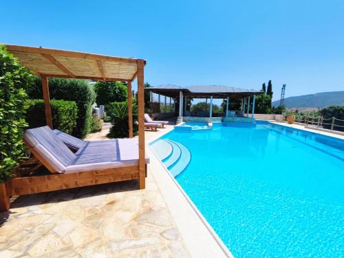 a swimming pool with chairs and a gazebo at Summer Villa Lagonissi in Lagonissi