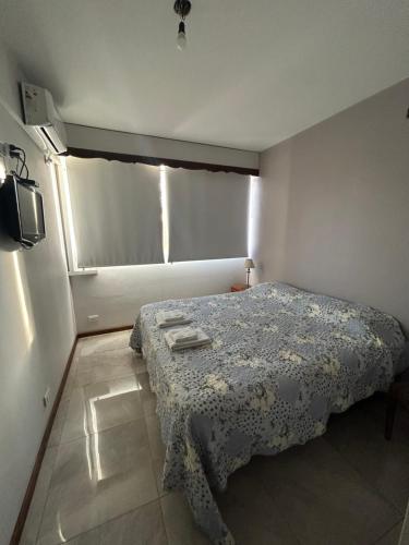 Habitación pequeña con cama y ventana en Depto Céntrico a Estrenar con cochera propia en Mendoza