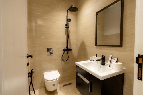bagno con servizi igienici, lavandino e specchio di Luxury Almalqa شقة فاخرة الملقا a Riyad