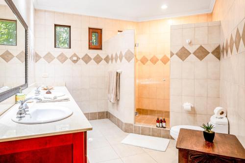 een badkamer met een wastafel en een douche bij Macaw Oceans Club #2 in Jacó