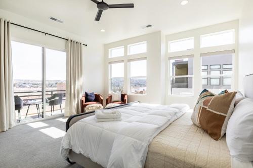 a white bedroom with a bed and a balcony at Villa 27 - 4 Bedroom Townhome! Pool and Hot Tub! in St. George