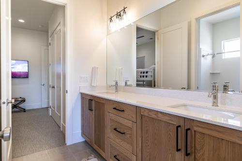 a bathroom with a sink and a large mirror at Villa 27 - 4 Bedroom Townhome! Pool and Hot Tub! in St. George