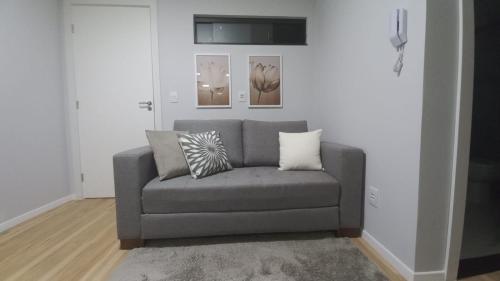 ein graues Sofa im Wohnzimmer mit zwei Kissen in der Unterkunft Studio Praia do jardim 1 305A in Angra dos Reis