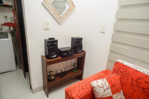 a living room with a couch and two speakers on a shelf at Downtown Apartments "Altos del Sur" in Santa Cruz de la Sierra