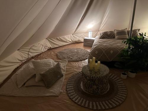 une tente avec un lit et une table avec des bougies dans l'établissement Noonamah Tourist Park, à Noonamah