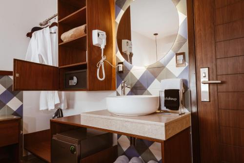 uma casa de banho com um lavatório e um espelho em Nuxká Hotel by Heaven em Telchac Puerto