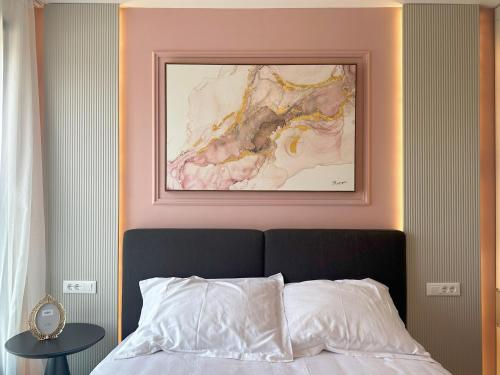 ein Schlafzimmer mit einem Gemälde über einem Bett in der Unterkunft Penthouse Amethyst with rooftop pool in Kožino