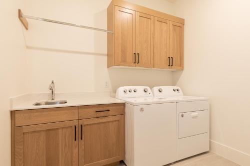 uma cozinha com armários de madeira e um frigorífico branco em Villa 28 - 4 Bedroom Townhome! Pool and Hot Tub! em St. George