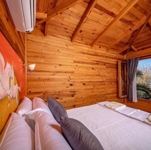 ein Schlafzimmer mit einem Bett in einem Zimmer mit Holzwänden in der Unterkunft Palmira Selimiye in Marmaris
