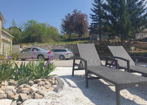 dois bancos sentados num quintal com um carro em Haus Natura em Jurdani