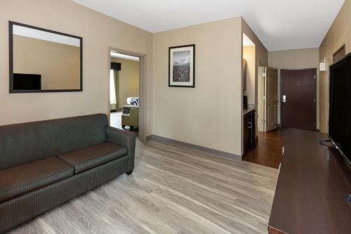 a living room with a couch and a television at La Quinta Inn & Suites by Wyndham Durant in Durant