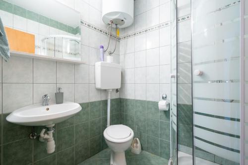 a bathroom with a toilet and a sink and a shower at Apartments with a parking space Mandre, Pag - 16836 in Mandre