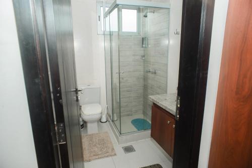 uma casa de banho com um WC e uma cabina de duche em vidro. em Downtown Apartments "Altos del Sur" em Santa Cruz de la Sierra