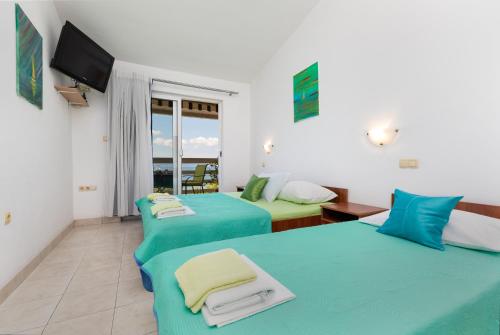 um quarto com 2 camas, uma televisão e uma varanda em Apartments by the sea Duce, Omis - 13694 em Omiš