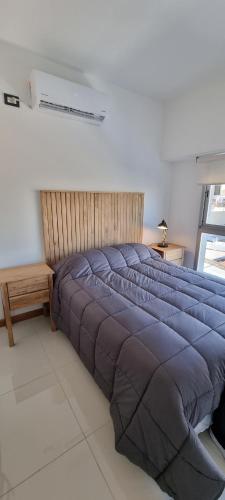 1 cama con manta azul en un dormitorio en Departamento Temporario 54, en La Plata