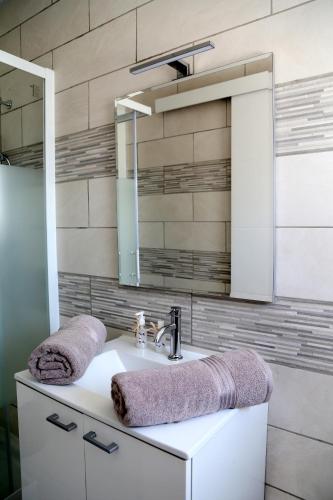 une salle de bain avec un lavabo et un miroir dans l'établissement Venus, à Saint-Quentin