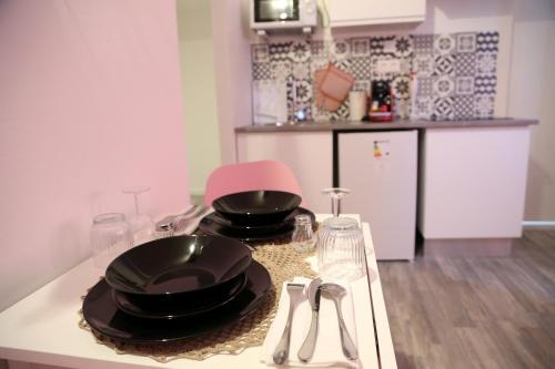 una cucina con due piatti neri e bicchieri su un bancone di Venus a Saint-Quentin