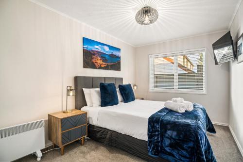 ein Schlafzimmer mit einem großen Bett und einem Fenster in der Unterkunft Awesomely Lakeview Queenstown Home in Queenstown