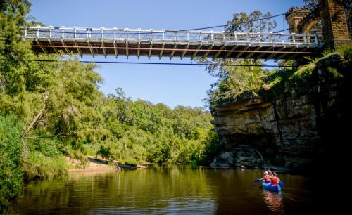 a couple of people kayaking under a bridge at The Red Barn right in the heart of historic Berry in Berry