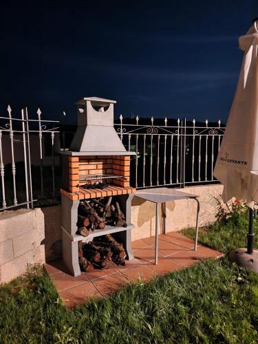 a brick oven with a table next to a fence at Villa los Dulces-Piscina Privada in Letur