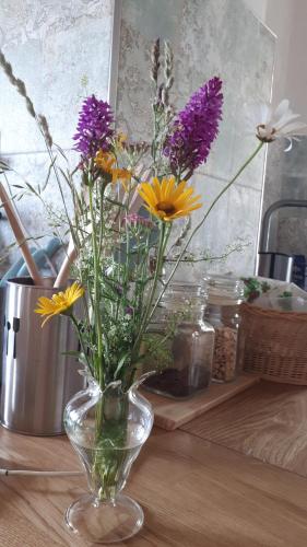 a vase filled with purple and yellow flowers on a table at Agriturismo La Pina in Tarzo